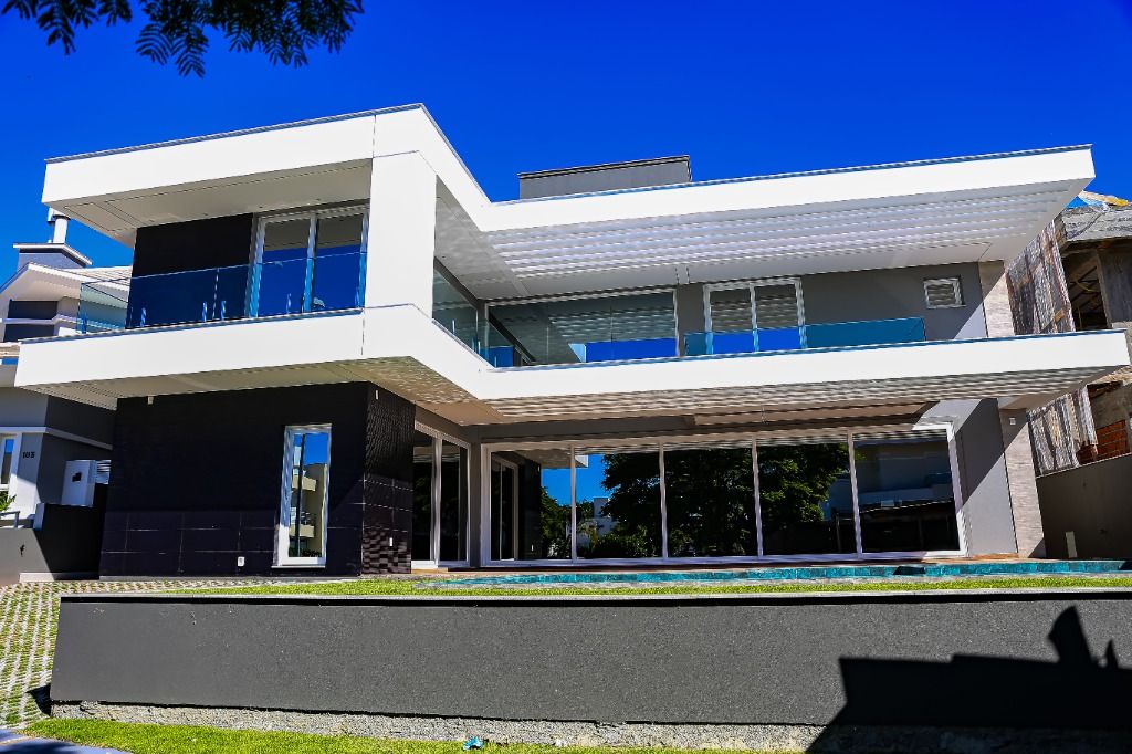 Casa em Jurerê, em Florianópolis, com céu azul e gramado